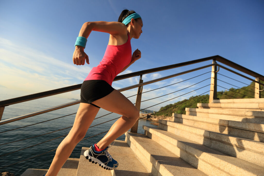Woman running up steps. Can running cause Can running wear and tear on your joints?