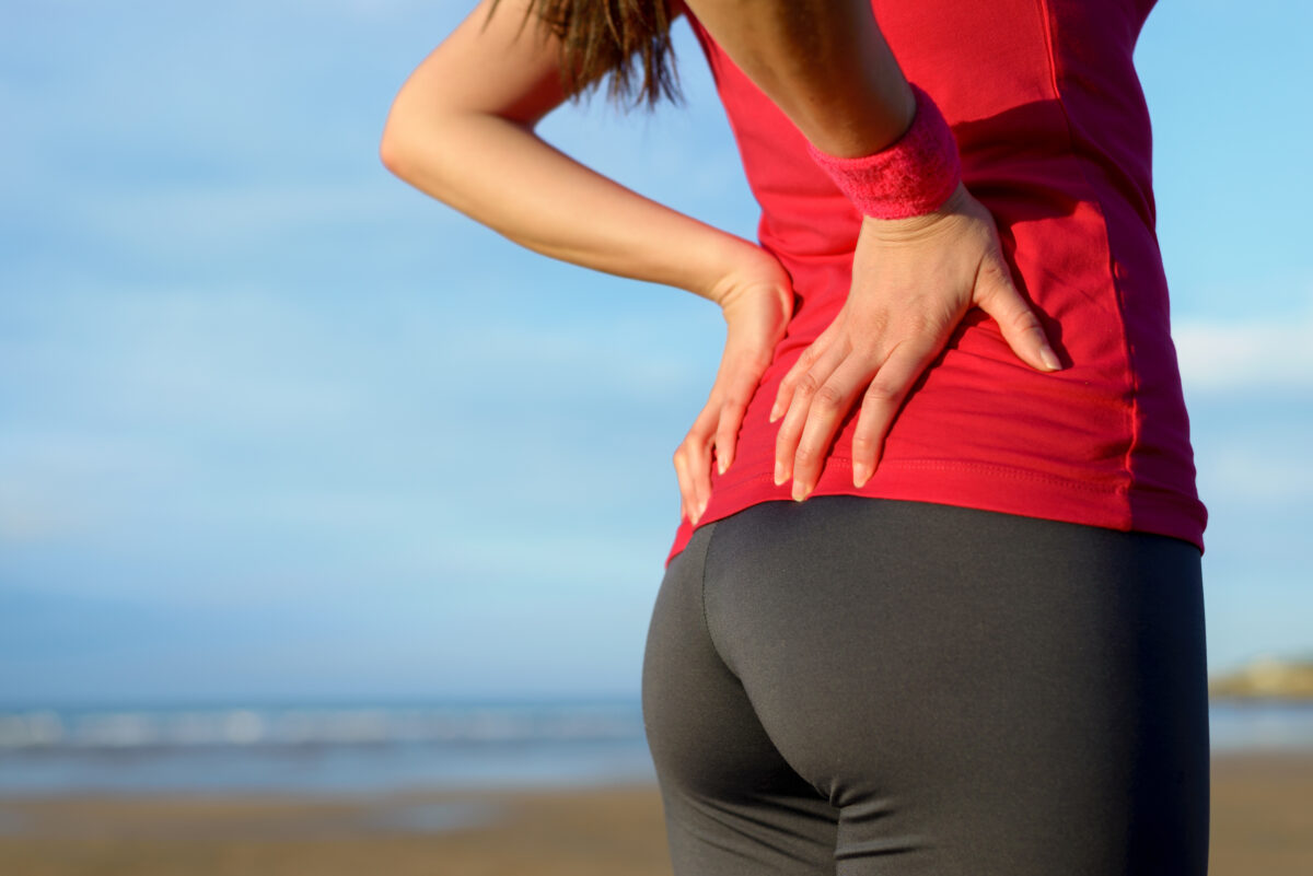 Woman holdning her lower back, like she's in pain